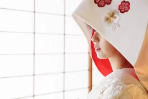 日本庭園の和室で、綿帽子をかぶった花嫁の横顔を撮影した白無垢の和装前撮り写真(撮影：スーパーカメラマン大川)