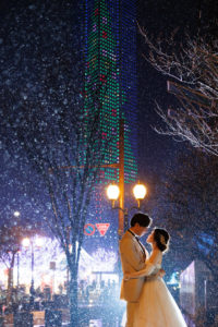 福岡タワーのイルミネーションと雨をバックに見つめ合うカップルの幻想的な洋装前撮り写真（撮影：スーパーカメラマン大川さん）